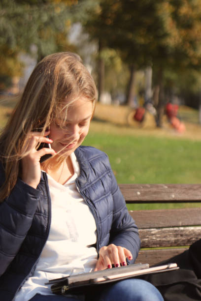 istock Young woman using her mobile phone in the public park 1055081536