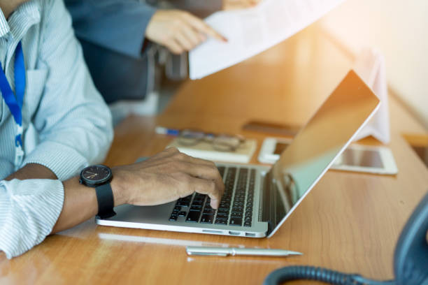 istock close up employee man  hand typing on keyboard laptop and listen briefing work data information from manager at office table , working team concept 1055083150