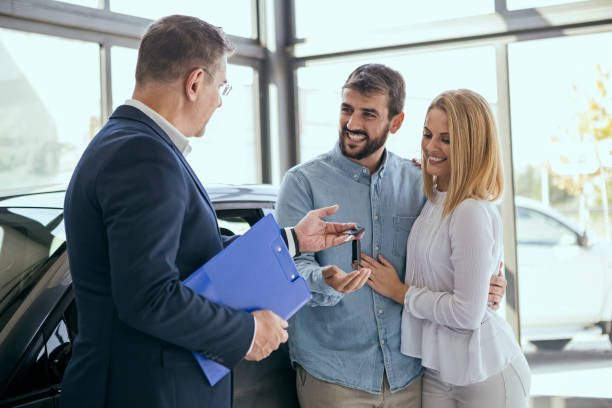 istock Young couple buying a car ,taking keys 1055085294