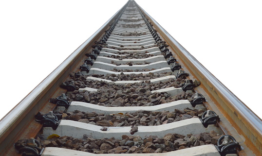 New railroad ties stacked along two rail lines.