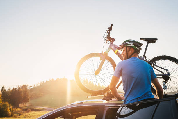 istock Man take his bicycle from car roof. Mountain biking concept 1055097504