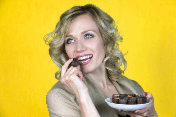 istock A woman with a beautiful smile is eating candy. 1055098056