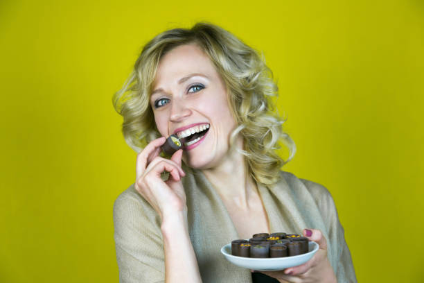 istock A woman with a beautiful smile is eating candy. 1055098066