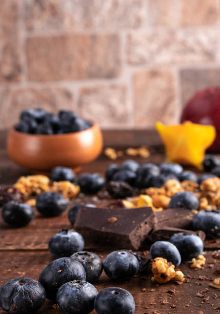 istock Fresh blueberries over a brown wood table with granola and dark chocolate 1055098338