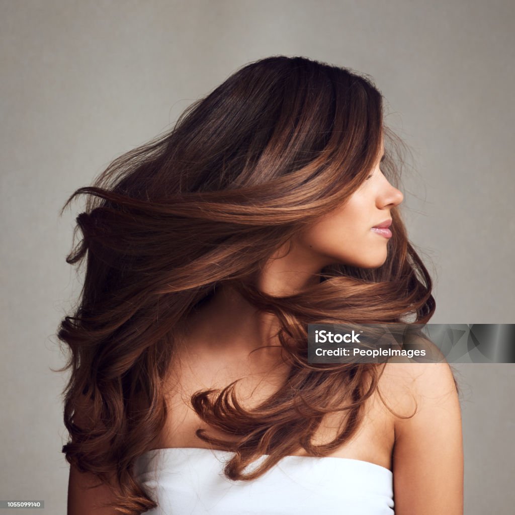 Making hairstory everyday with gorgeous hair Studio shot of a young beautiful woman with long gorgeous hair posing against a grey background Women Stock Photo