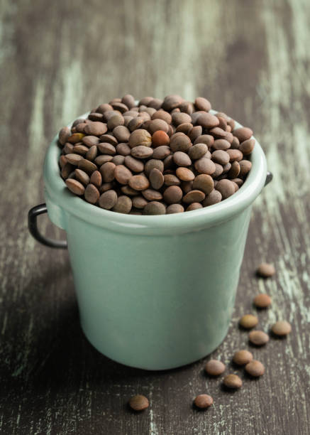 istock Ceramic bowl with raw lentils on wooden background. 1055101028