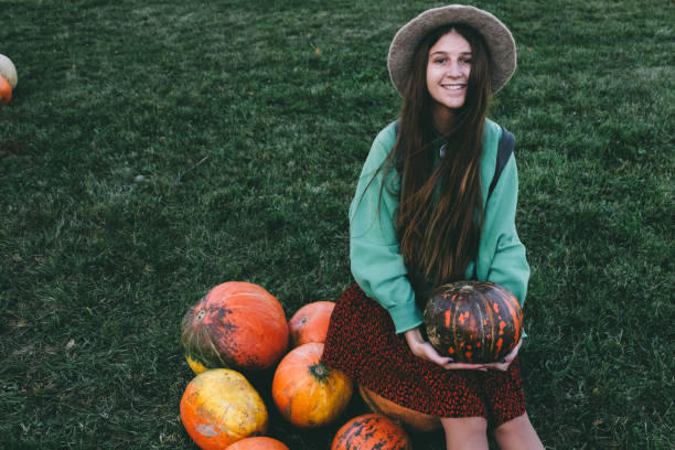 istock Beautiful woman in hat with pumpkin 1055110516