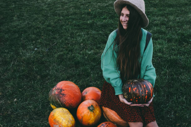 istock Beautiful woman in hat with pumpkin 1055110580