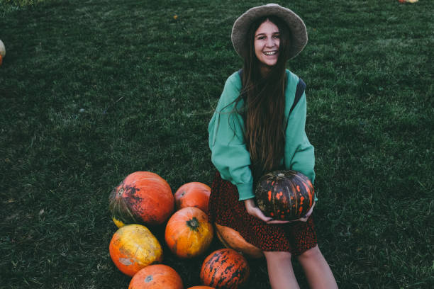 istock Beautiful woman in hat with pumpkin 1055110710