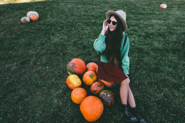 istock Beautiful woman in hat with pumpkin 1055110716