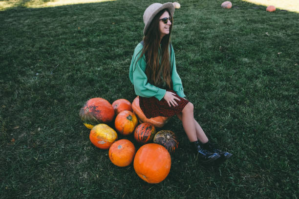 istock Beautiful woman in hat with pumpkin 1055110802
