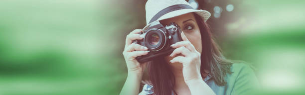 istock Portrait of pretty young woman using a camera 1055128552
