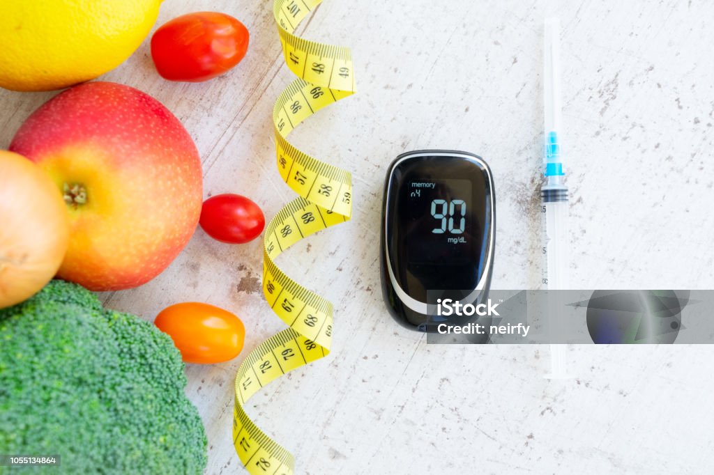 Diabetes healthy diet Diabetes healthy diet concept, raw vegetables with blood glucose meter and insulin syringe Concepts Stock Photo