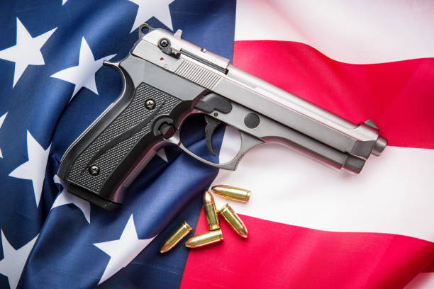 istock Pistol bullets, handgun on USA flag. 1055137968