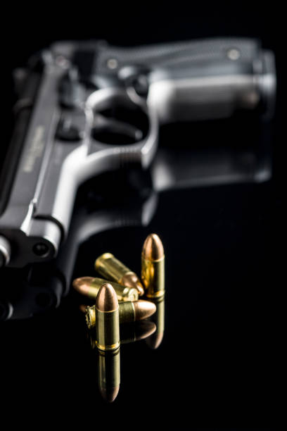 istock 9mm pistol bullets and handgun 1055138044