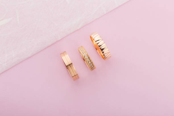 istock Stylish pink gold rings with different design on pink background 1055140118