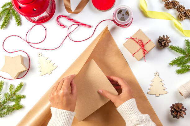 istock Christmas gift wrapping. Woman's hands packing Christmas present box in craft paper 1055160436