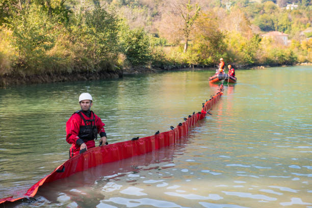 Dam construction on the river - rescue operation with a boat, oil spill Firefighters in a rescue operation; all logos removed. Slovenia, Europe. Nikon. flood preparation stock pictures, royalty-free photos & images