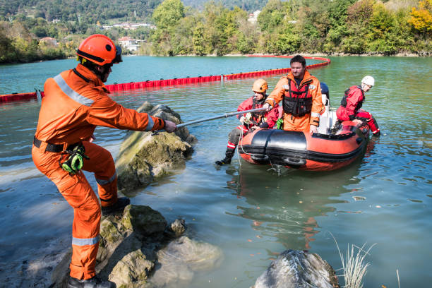 Dam construction on the river - rescue operation with a boat, oil spill Firefighters in a rescue operation; all logos removed. Slovenia, Europe. Nikon. neoprene photos stock pictures, royalty-free photos & images