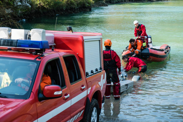 Dam construction on the river - rescue operation with a boat, oil spill Firefighters in a rescue operation; all logos removed. Slovenia, Europe. Nikon. flood preparation stock pictures, royalty-free photos & images
