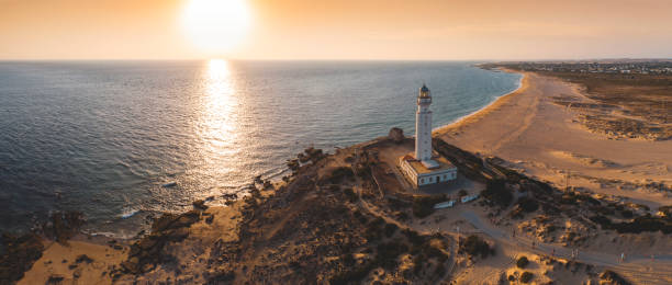 coucher de soleil phare - cadiz andalusia beach spain photos et images de collection