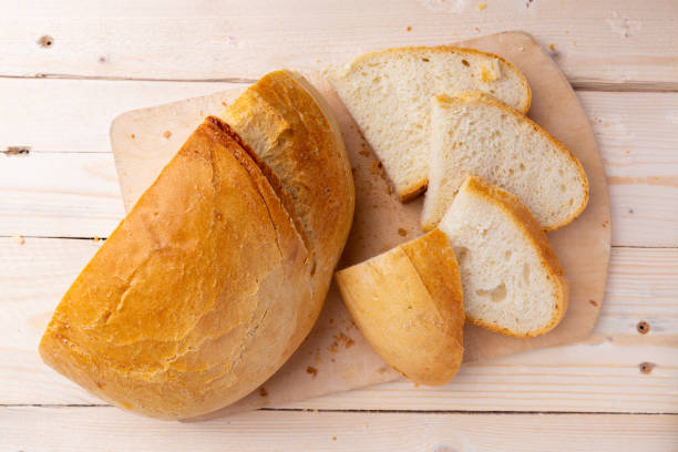 istock White sliced bread on cutting board on wooden background. Concept bread. top view 1055176672