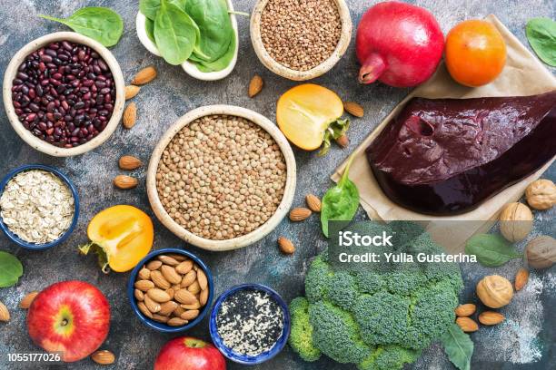 Foods High In Iron Liver Broccoli Persimmon Apples Nuts Legumes Spinach Pomegranate Top View Flat Lay Stock Photo - Download Image Now