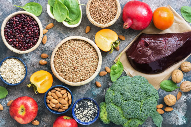 foods high in iron. liver, broccoli, persimmon, apples, nuts, legumes, spinach, pomegranate. top view, flat lay. - base comida e bebida imagens e fotografias de stock