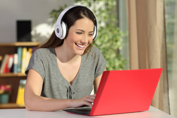 istock Girl e-learning with a laptop and headphones at home 1055182064