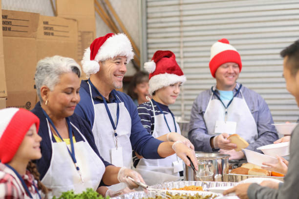 Multi-ethnic volunteers serves food at soup kitchen at Christmas.