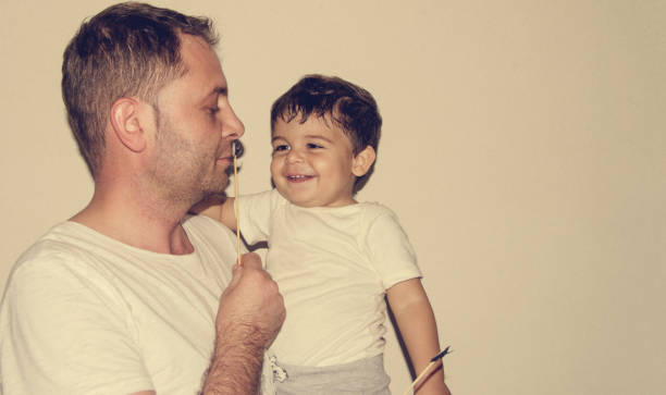 Father and son playng with moustache funny faces Father and son playng with moustache funny face expressions, family time masculinity photos stock pictures, royalty-free photos & images