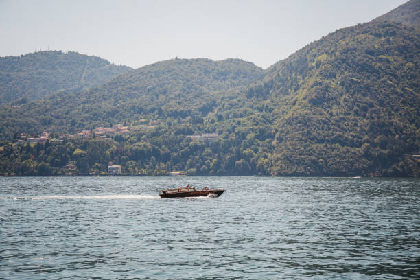 Lake Como, Italy - July 6, 2017: Speed boat on Lake Como, on a bright summer day.  Lake Como is the third-largest lake in Italy after lakes Garda and Maggiore.