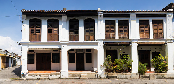 Panoramic view of several Penang residential buildings built in a row in George town's historic district in the characteristic colonial style.