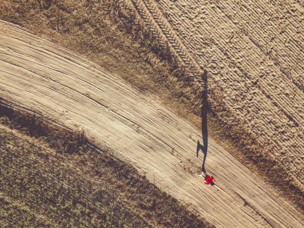 istock drone view on woman running on field 1055197672