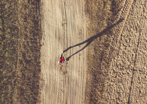 istock drone view on woman running on field 1055197868
