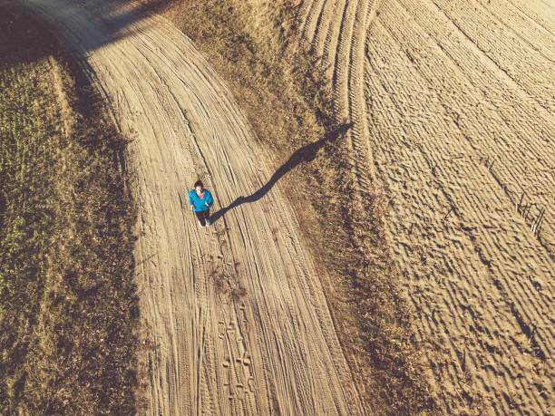 istock drone view on woman running on field 1055198160
