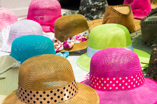 WIde brimmed sun hats adorned with bows. Ladies fashion, variety, market stand, sales concepts