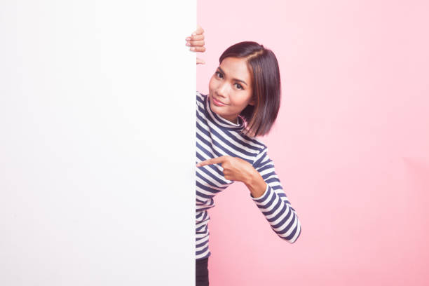 istock Young Asian woman point to a  blank sign. 1055206682