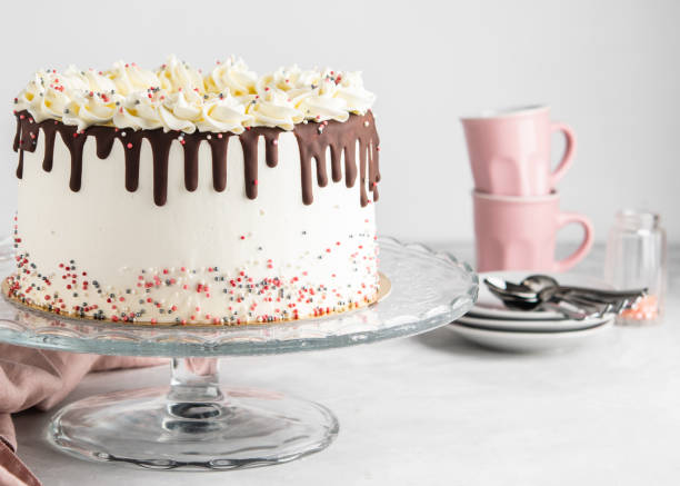 istock Easy Birthday Drip Cake with chocolate ganache and sprinkles on a white background with party decor. Horizontal. Copy space. Celebration concept. Trendy Drip Cake. 1055209668