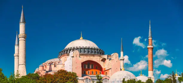 Hagia Sophia (Holy Wisdom) Ottoman imperial mosque and now a museum (Ayasofya Müzesi) in Istanbul, Turkey. Blue sky with clouds in background.