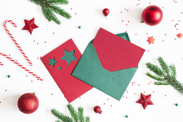 istock Christmas composition. Envelope, fir tree branches, red and green decorations on white background. Christmas, winter, new year concept. Flat lay, top view, copy space 1055214012