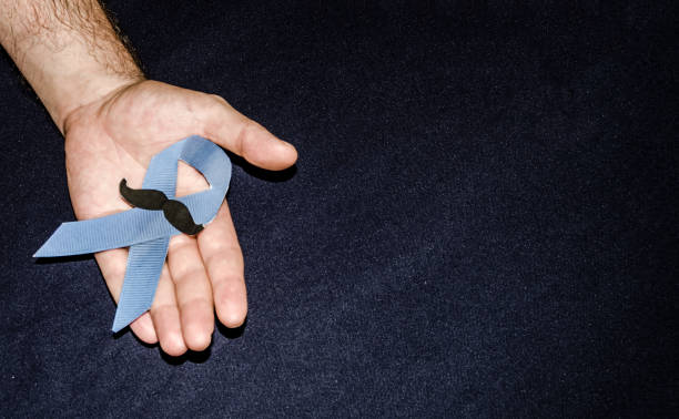 istock Man holding a blue ribbon, blue november concept 1055214162