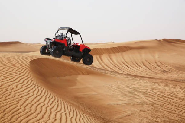 Off-road SUV vehicle speeding through sand dunes in the Arabian desert. Off-road SUV vehicle speeding through sand dunes in the Arabian desert desert safari stock pictures, royalty-free photos & images