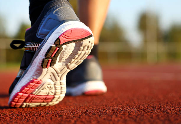 istock Woman running on athletic track 1055216878