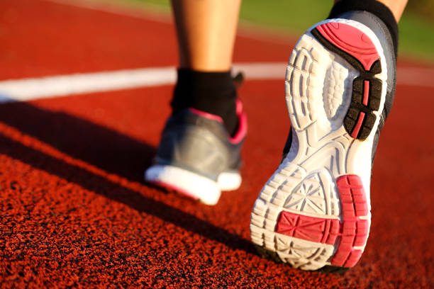 istock Woman running on athletic track 1055216886