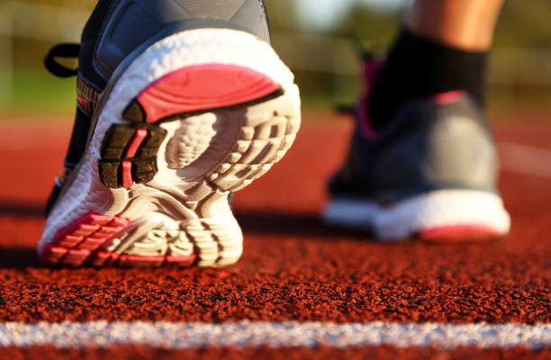 istock Woman running on athletic track 1055216908