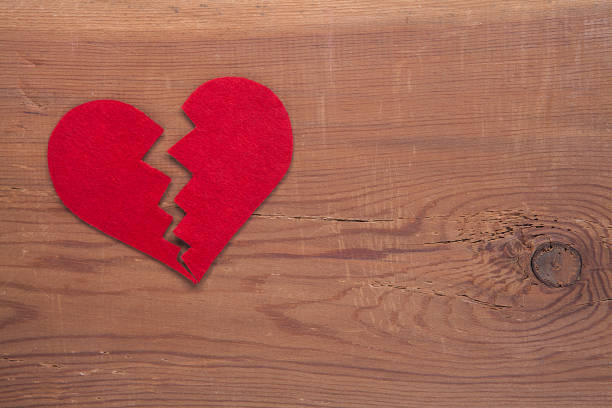 istock Tiny red heart sign isolated on wooden background. 1055217166