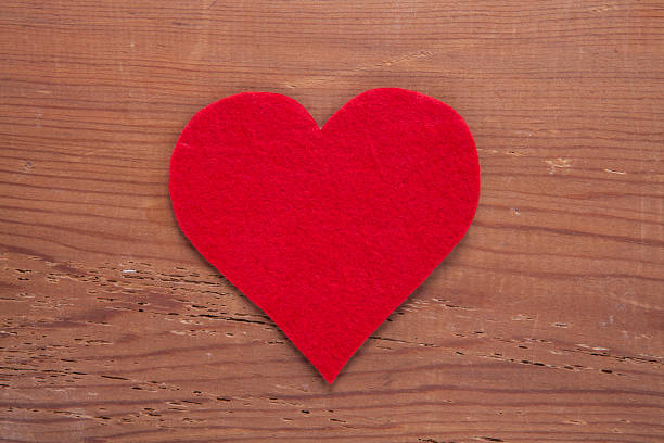 istock Tiny red heart sign isolated on wooden background. 1055218784