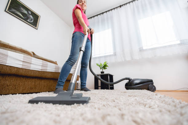 istock Young woman vacuuming house 1055222430