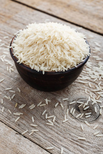 istock raw long rice in a plate on a wooden table. 1055222568
